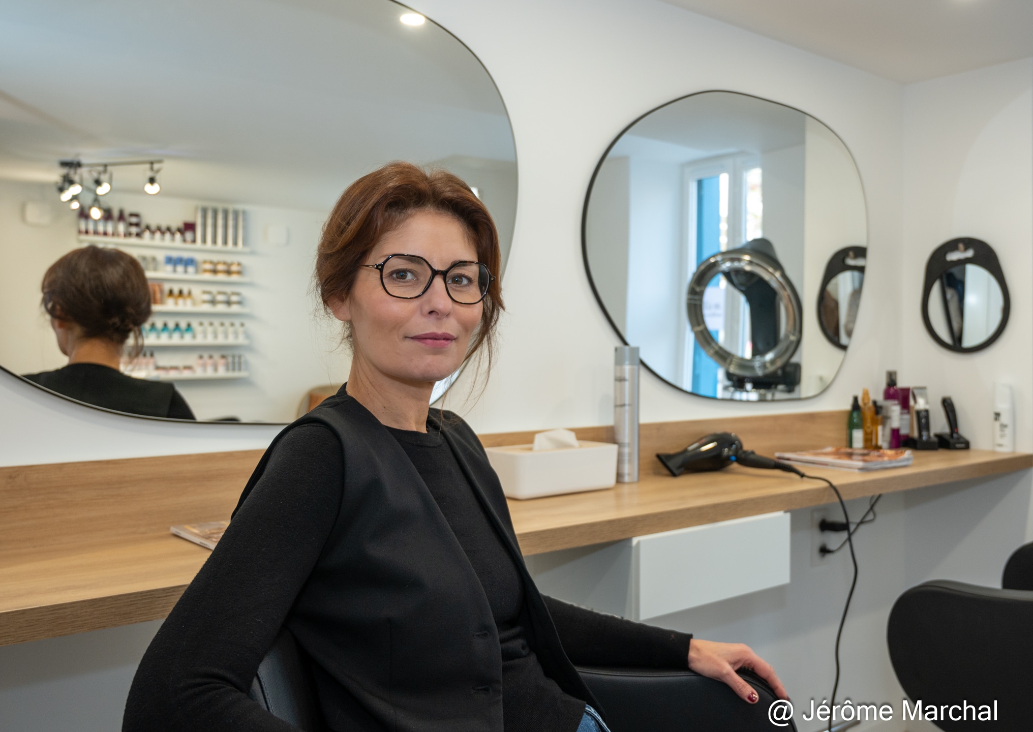 Photo présentant une femme dans un salon de coiffure. Il s'agit de Nadia Marchal, propriétaire du salon Nadia M. Coiffeur.